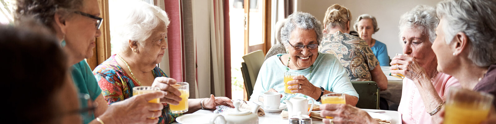 A group of senior women having breakfast at a table in a senior living facility