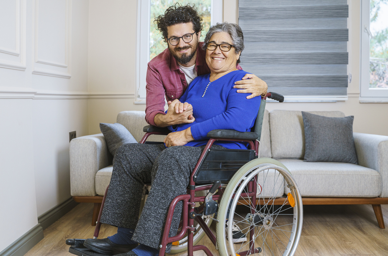 A senior man and woman sitting together on a park bench smiling and laughing together